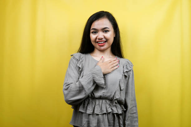 istock Beautiful young woman with hands holding chest isolated 1359314922