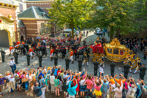 King Willem-Alexander and Queen Máxima waving to the public on Prince's Day, from the glazed koets, the glass carriage