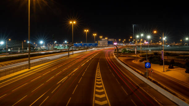 катарское шоссе с множеством световых трасс, снятых ночью с длительной экспозици�ей. - middle east highway street night стоковые фото и изображения