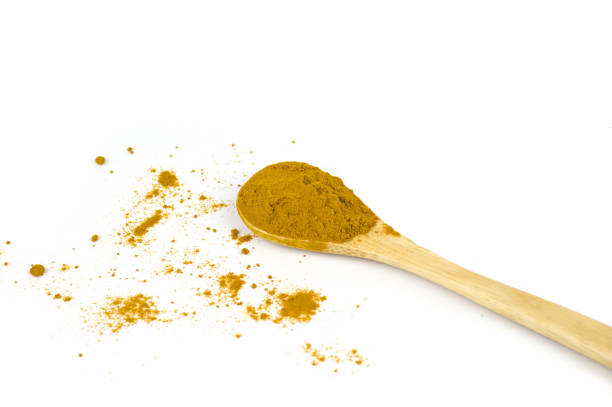 istock Turmeric on wooden spoon isolated on white background 1359321178