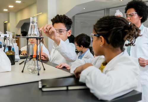 Freshman Science Work Diverse Schoolchildren With Teacher Work Together On Science Project ...
