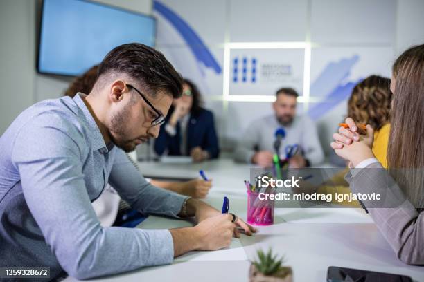 Journalist Writing Down Notes During The Press Conference Int He Media Centre Stock Photo - Download Image Now
