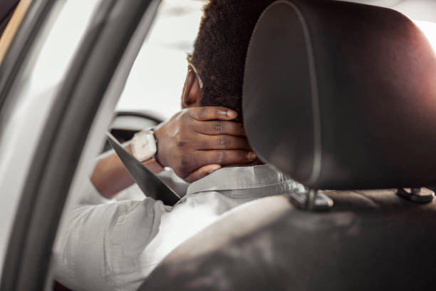 мужчина, испытывающий бо�ль в шее во время вождения автомобиля - human spine human age horizontal outdoors стоковые фото и изображения