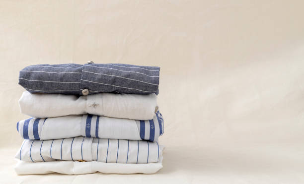 istock Stack of striped linen,cotton shirts on the beige organic linen fabric.Empty space 1359329175