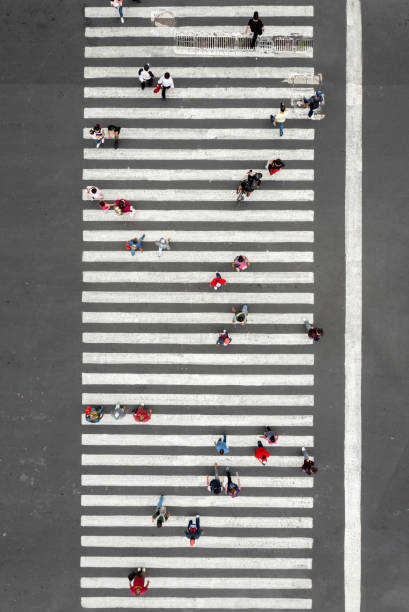 vista aérea de una multitud cruzando la calle - crossing zebra crossing crosswalk street fotografías e imágenes de stock