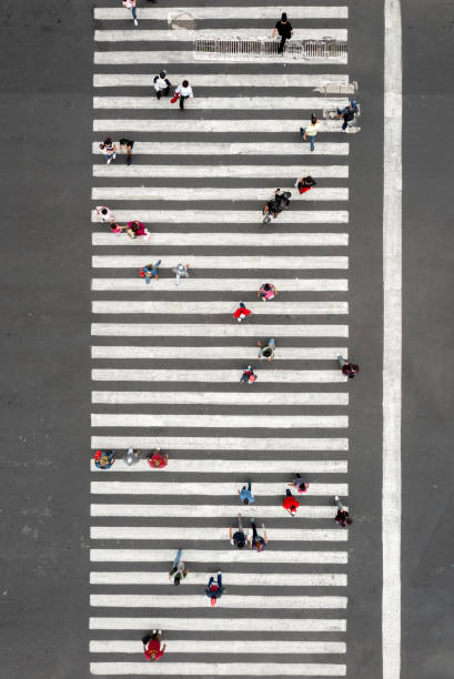 Aerial view of a crowd crossing the street Aerial view of a crowd crossing the street crosswalk stock pictures, royalty-free photos & images