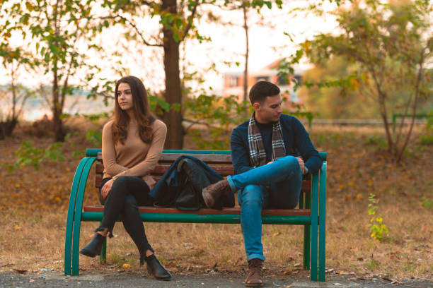istock Angry couple sitting on a bench and looking in opposite directions. 1359333278