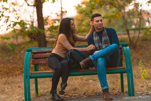 istock Angry boyfriend refusing to talk to his beautiful girlfriend,while sitting in a park. 1359333282