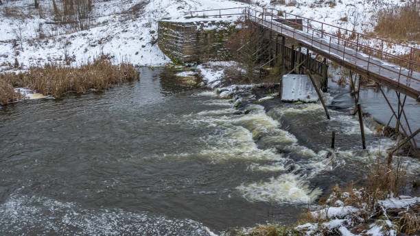istock Boiling water in a winter river under a pedestrian bridge. Abstract background. Space for text. 1359333412