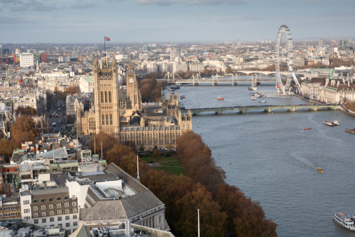 Viewed from the top of the 118m tall Millbank Tower, key landmarks are clearly visible - the Houses of Parliament, Big Ben, the London Eye and the three bridges - Westminster, Hungerford and Waterloo. The Union Jack is flying above the Victoria Tower indicating the house is sitting.