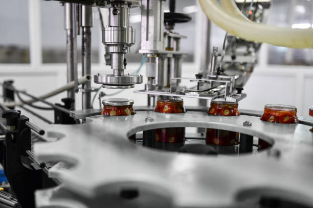 istock Machine Putting Cap On Food Conservation Jars Full Of Cherries 1359339900