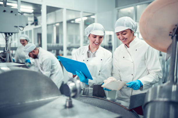 istock Factory Workers Filling Machine With Cottage Cheese For Stuffed Peppers In Jars 1359340547
