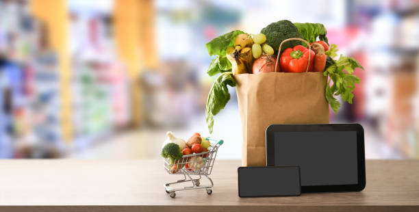 fondo de compras en línea con dispositivos y bolsa de compras en el supermercado - red potato raw potato market red fotografías e imágenes de stock