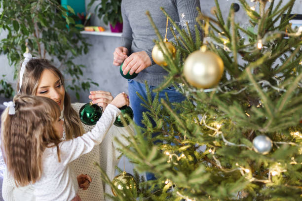 istock Family decorates Christmas tree at home 1359340892