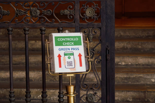 Green pass coronavirus control message in Italian and English at the entrance of a public building. stock photo