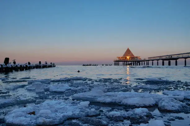 View towards the famous pier of Heringsdorf / Germany on the Baltic Sea with ice floes in the foreground