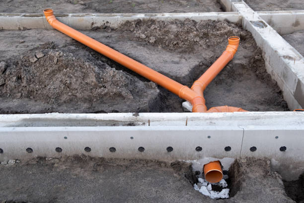 istock Sewer Line developed and mounted on the construction site. New Orange PVC plastic Drainage pipe Tube installed 1359342564