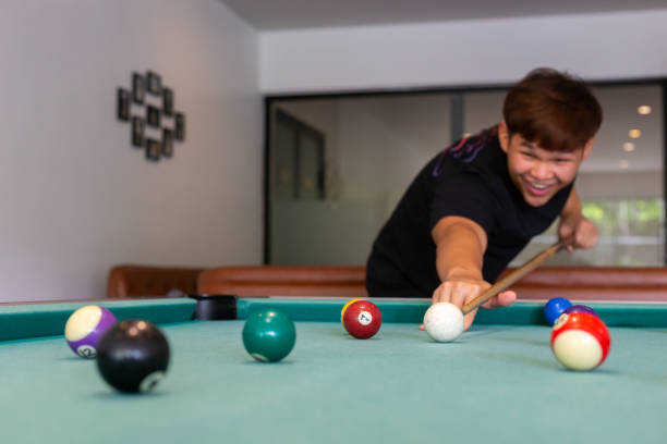 istock A man in black shirt playing pool or billiard in a pool hall, focus on background, horizontal 1359344533