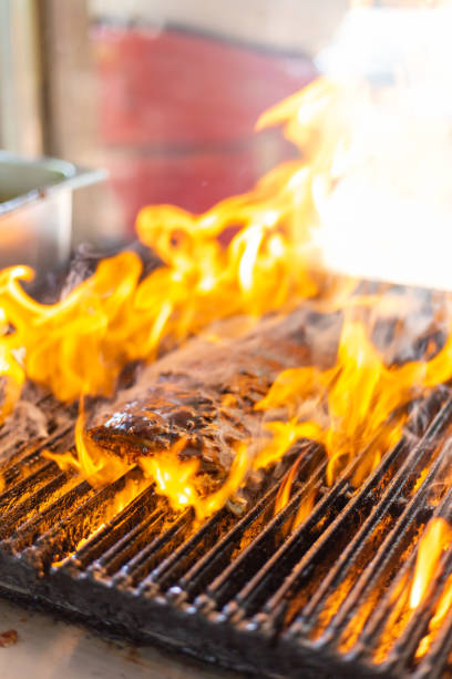 istock Pork spare-ribs grilled on fire flame, on smoked barbeque grill roaster, vertical 1359344977
