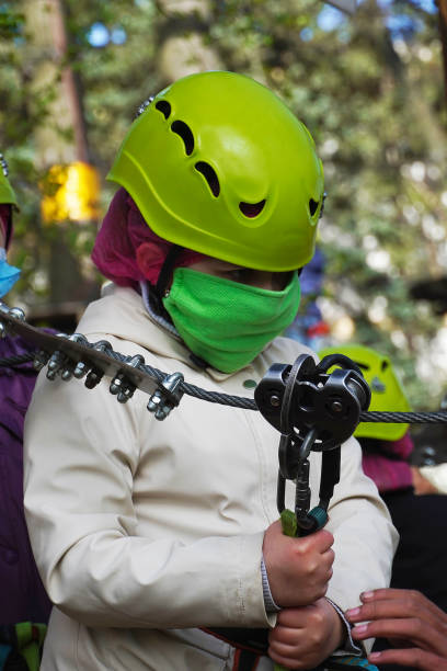 criança de capacete, máscara facial e equipamento ouvir o briefing do treinador antes de subir no parque de cordas. - education high up sport sports helmet - fotografias e filmes do acervo