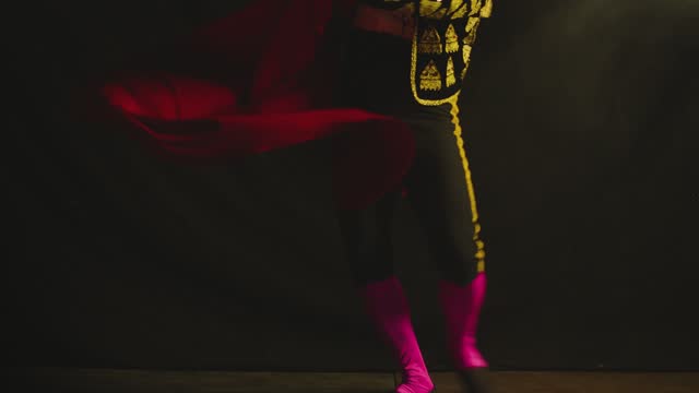 Male dancer or toreador imitating moves of matador bullfighter on black smoky background .  Man bullfighter dressed in bullfighting costume . Shot on ARRI Alexa cinema camera in Slow Motion