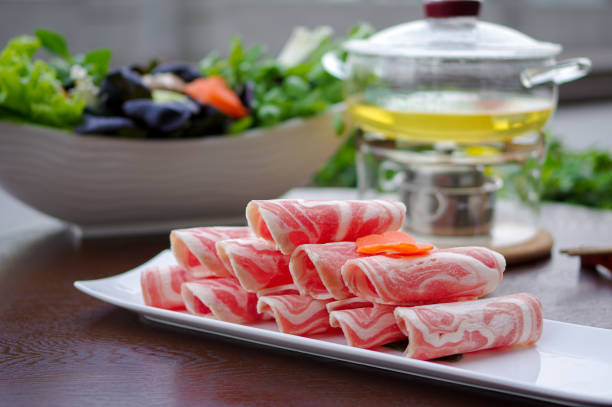 Sliced frozen raw lamb rolls for shabu shabu hot pot Hot pot or hotpot, also known as soup-food or steamboat, is a cooking method that originated in China, prepared with a simmering pot of soup stock at the dining table, containing a variety of Chinese foodstuffs and ingredients.
Shabu-shabu is a Japanese nabemono hotpot dish of thinly sliced meat and vegetables boiled in water and served with dipping sauces. The term is onomatopoeic, derived from the sound – "swish swish" – emitted when the ingredients are stirred in the cooking pot. mutton roll for chinese hot pot stock pictures, royalty-free photos & images
