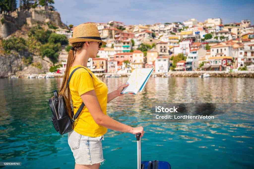 Woman on vacation at the sea Young woman tourist on vacation checking the map Adult Stock Photo