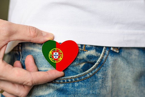 Patriot of Portugal! Wooden badge with flag of Portugal in the shape of a heart in a man's hand.