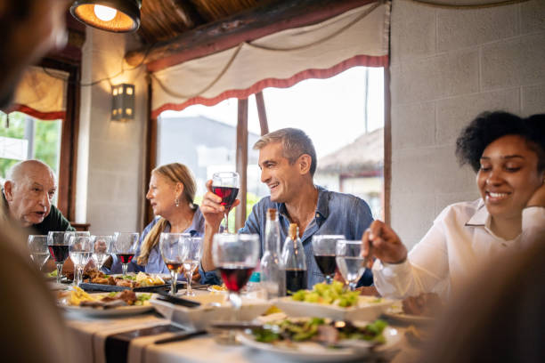 istock Mature man drinking red wine during family lunch at restaurant 1359351026