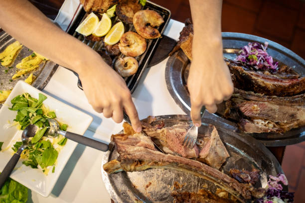 Hands of a man eating meat at a restaurant.  Close-up of a man having lunch at restaurant.