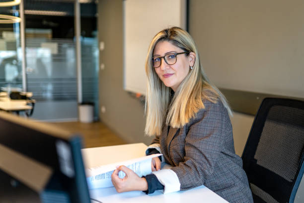 istock Middle-aged female professor sitting in classroom at university 1359351313