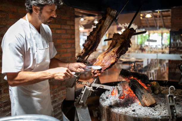 istock Male chef taking a piece of cooked meat cooked over coal in a restaurant kitchen 1359351341