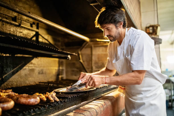 istock Cook wearing apron preapring meat in the grill 1359351400