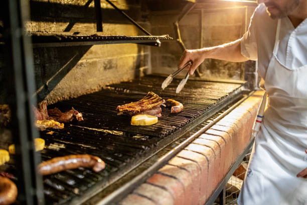готовьте мясо на гриле на кухне ресторана - barbecue grill chef barbecue sausage стоковые фото и изображения