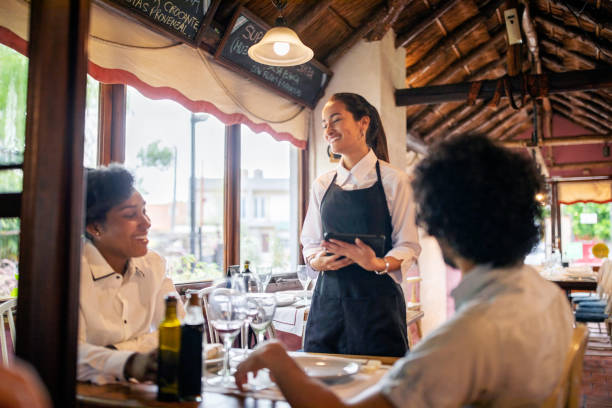 friendly waitress taking lunch order from couple at a restaurant - couple restaurant day south america imagens e fotografias de stock