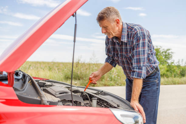 senior man checking oil in car - old men car oil imagens e fotografias de stock