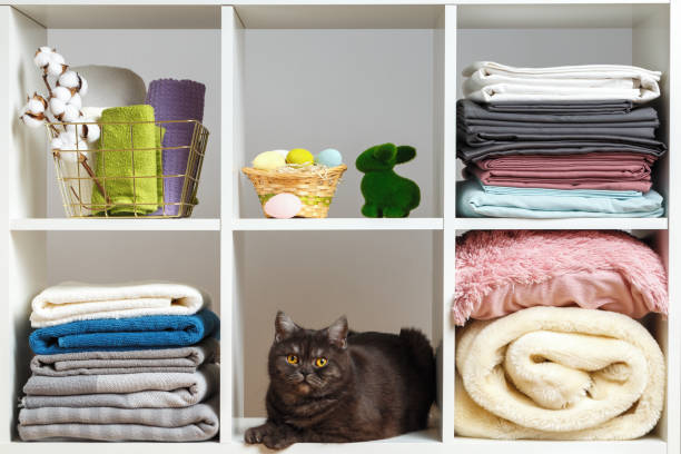 istock Stacks of towels, sheets, bed linen, blankets and pillows on a white shelf. Organization of storage. Easter celebration 1359353249