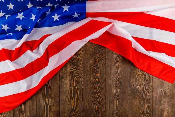 istock crumpled usa flag on flat textured wooden surface background 1359354672