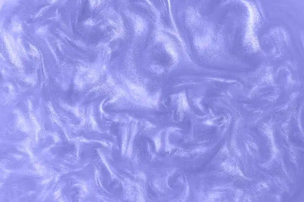 Photo of Violet paint background. Motion of the shiny liquid. Color of the year 2022 very peri. Waves on a glittering liquid.