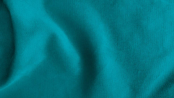 istock close up creased bright blue shiny silk fabric texture use as background with space for design. abstract smooth elegant cyan fabric texture. soft satin silk background with flowing waves. 1359357902