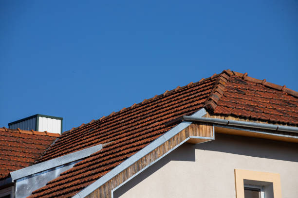 istock Ceramic tile roof with chimney and white wall, blue sky as background 1359364398