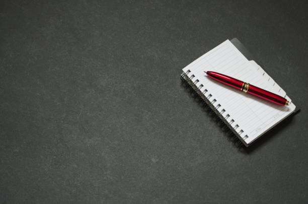 Small paper notepad with red ballpoint pen