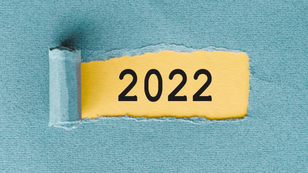 istock The text 2022 on yellow background under blue paper layer 1359366637