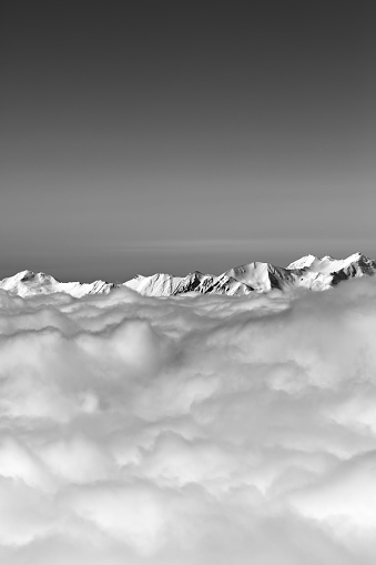 Black and white high mountains under clouds in winter day. Caucasus Mountains, Georgia, region Gudauri.