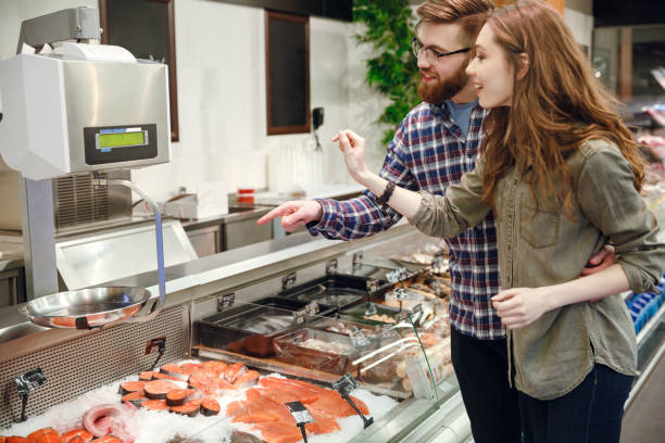 istock Side view of couple choosing fish 1359368046