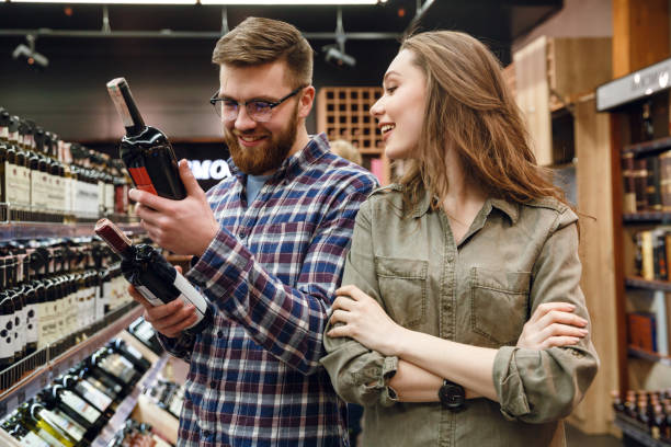 istock Young  couple choosing bottle of wine 1359369702