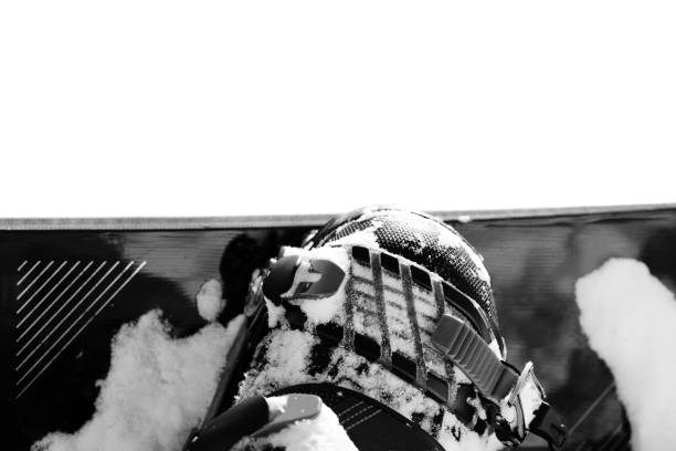 A snowboarder dressed in red is captured as they make a sharp turn on a snowy mountain terrain. The action creates a flurry of snow, showcasing the energy and thrill of winter sports in the cold, misty atmosphere.