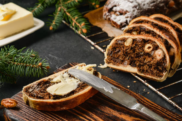 Pieces of Swiss Pear Bread - Bündner Birnbrot, close up on the table. Traditional Christmas and New Year's meal. Birnbrot is smeared with butter and served with coffee. Selective focus stock photo