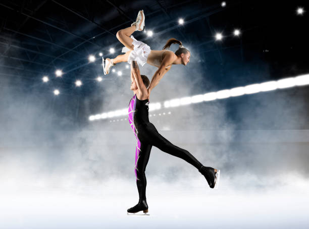patinador artístico dúo en acción sobre fondo oscuro - patinaje artístico fotografías e imágenes de stock