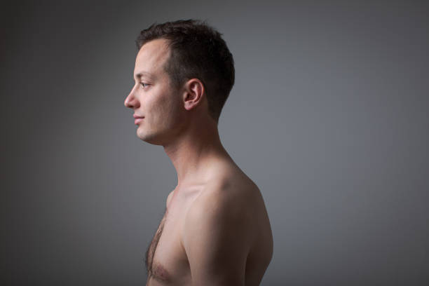 Dark (low key) portrait of a, handsome young man on grey background